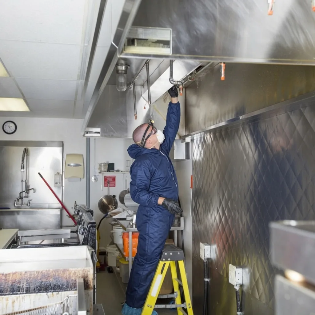 Southeast Commercial Services technician degreasing a commercial kitchen exhaust hood in Atlanta